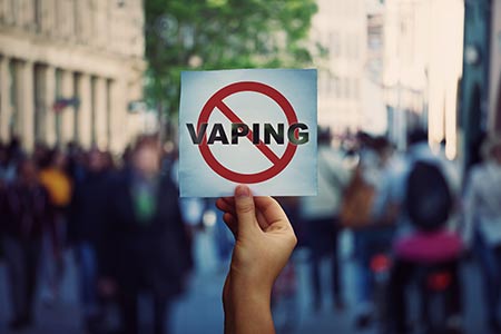 Person holding a no vaping sign