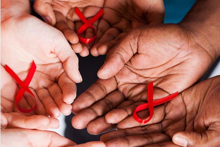 Hands holding AIDs HIV awareness ribbons