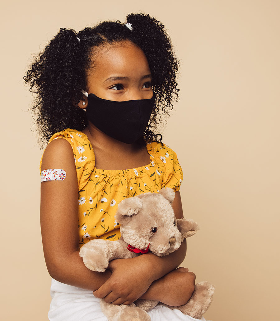 Girl with teddy bear wearing bandaid from vaccination