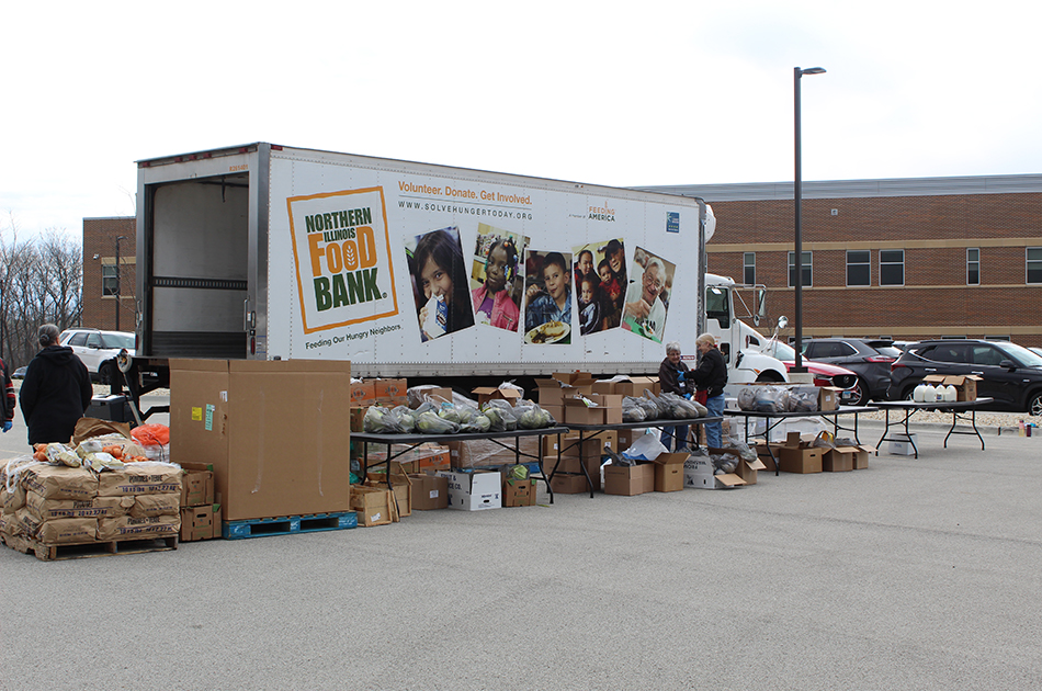 Photo of Mobile Food Bank Truck with packages and workers providing food